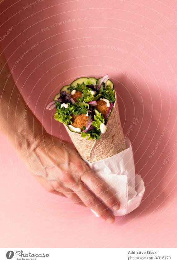 Anonyme Person hält veganen Falafel-Wrap in den Händen Hartweizen vereinzelt Bestandteil Fastfood fajitas Schawarma halal Kichererbsen Restaurant Bälle arabisch