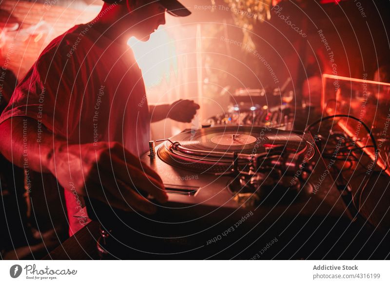 DJ mischt Musik während einer Party in einem Club dj Nachtclub Regler Konzert Mann neonfarbig männlich Klang unterhalten Audio ausführen Gerät Mixer Gesang