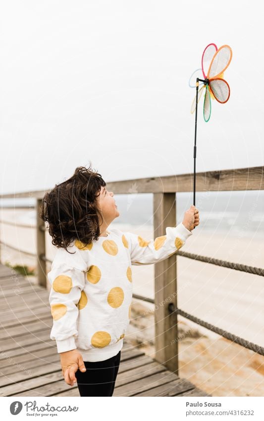 Kind hält Windmühle Spielzeug am Strand Kaukasier Mädchen 1-3 Jahre Spielen Freizeit & Hobby Freude Lifestyle Kindheit Kleinkind Farbfoto Mensch Außenaufnahme