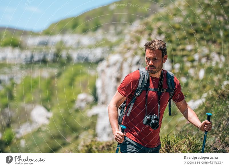 Männlicher Wanderer mit Trekkingstöcken in bergigem Terrain Tourist Wanderung Mast Hochland Fotoapparat Rucksack Felsen Tourismus Natur Reisender reisen
