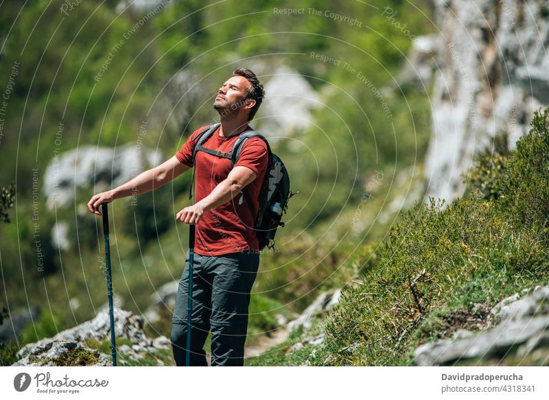Männlicher Wanderer mit Trekkingstöcken in bergigem Terrain Tourist Wanderung Mast Hochland Rucksack Felsen Tourismus Natur Reisender reisen Abenteuer erkunden