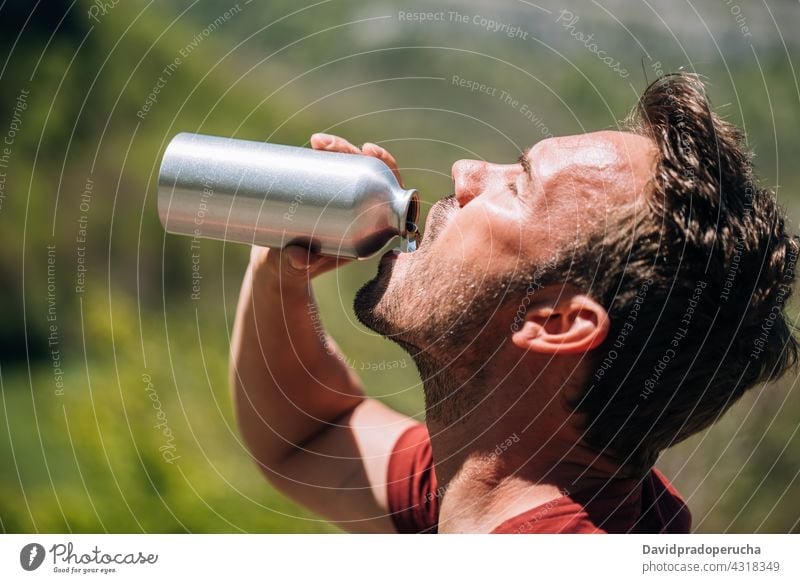 Durstiger Mann trinkt Wasser aus wiederverwendbarer Flasche Tourist trinken wiederverwenden keine Verschwendung Tourismus Pause Abenteuer heiß umweltfreundlich