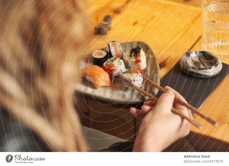 Anonyme Frau isst Sushi in einem asiatischen Restaurant essen rollen Kulisse Asiatische Küche lecker geschmackvoll Lebensmittel Tisch Orientalisch Mahlzeit