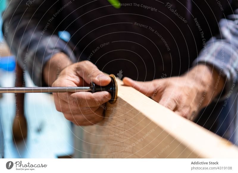 Schreiner mit Anreißlehre für Holzarbeiten Zimmerer Tischlerin Mark Messgerät Mann Werkzeug messen Werkstatt Schreinerei Kunsthandwerker Arbeit männlich