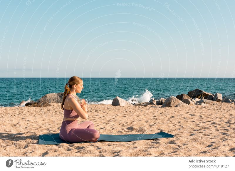 Frau meditiert in Lotus-Pose am Strand Yoga meditieren Asana Zen sich[Akk] entspannen padmasana Harmonie Achtsamkeit ruhig Wellness Gesundheit Stressabbau