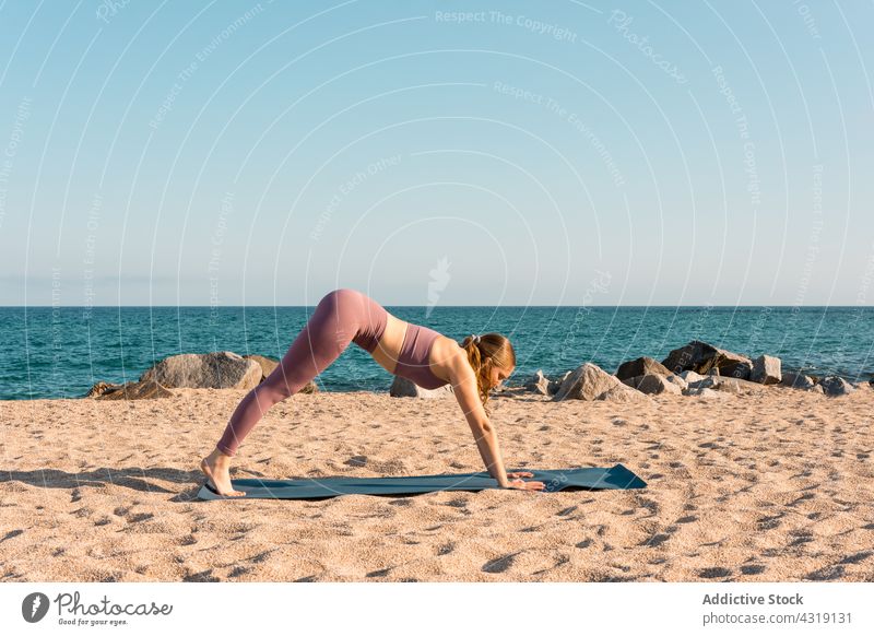 Frau macht Yoga in Downward Facing Dog Pose am Strand üben Harmonie nach unten gerichtete Hundehaltung Dehnung beweglich Asana MEER Sand Gesundheit