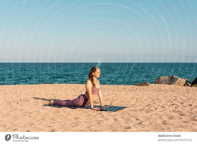 Frau übt Yoga in Kobra-Pose am Meeresufer Strand Dehnung beweglich Asana Harmonie üben Gesundheit Zen Sand Ufer Gelassenheit Sprit Körper bhujangasana ruhig