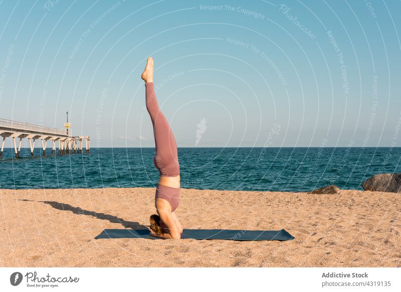 Frau übt Yoga im Kopfstand am Strand Pose Gleichgewicht Salamba sirsasana Zen Meeresufer üben Asana Wellness Harmonie Unterlage Gesundheit ruhig beweglich Ufer