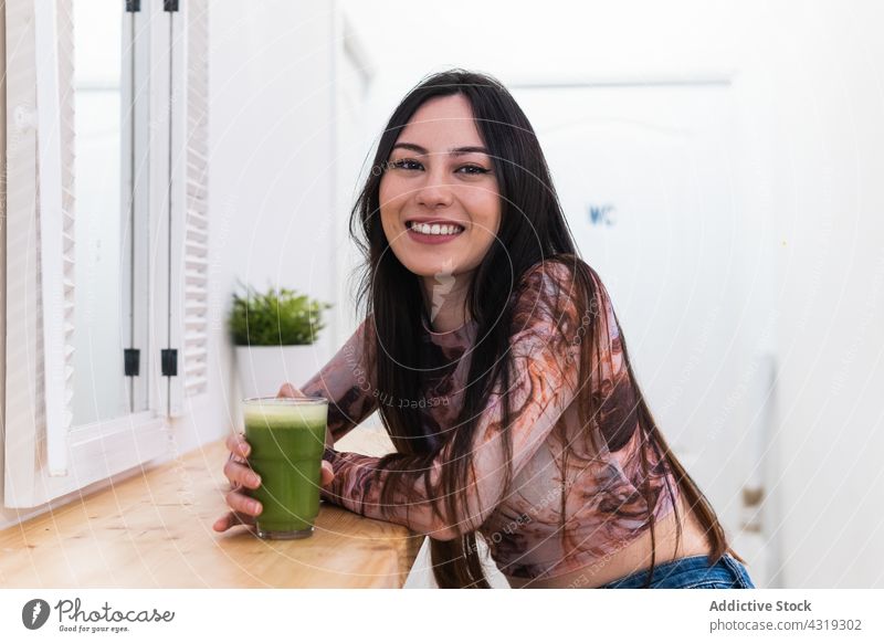 Zufriedene Frau genießt ein grünes Getränk in einer Bar Kälte Wochenende genießen Abfertigungsschalter Inhalt heiter sich[Akk] entspannen Lächeln Freude modern