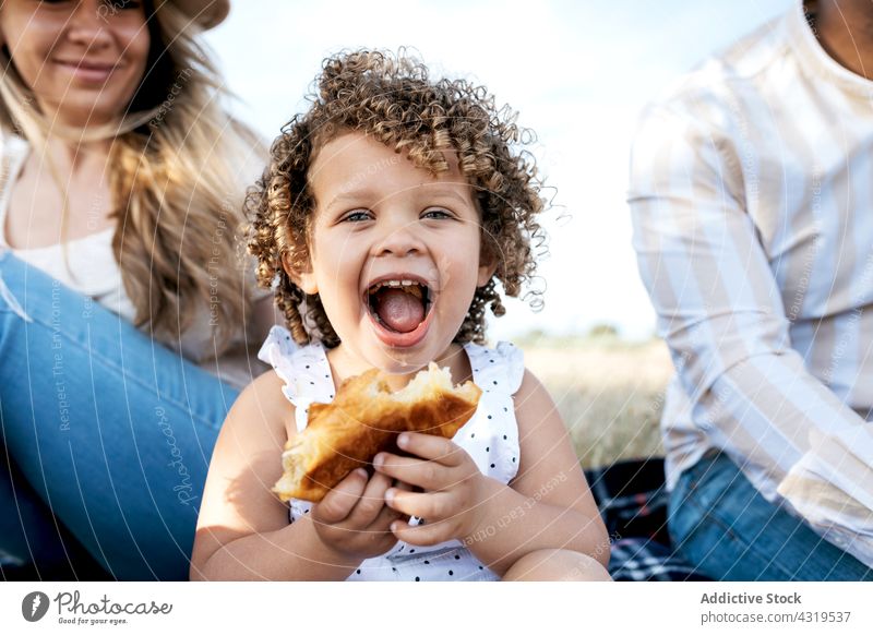 Glückliche multiethnische Familie beim Picknick in der Natur essen Kind Zusammensein genießen Sommer rassenübergreifend vielfältig Mädchen schwarz
