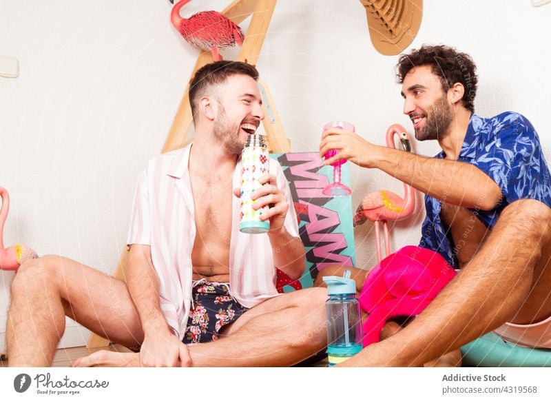 Fröhliches schwules Paar genießt Strandparty Homosexualität lgbt Sommer Party trinken Männer Zusammensein lustig Spaß haben Kälte genießen so tun, als ob