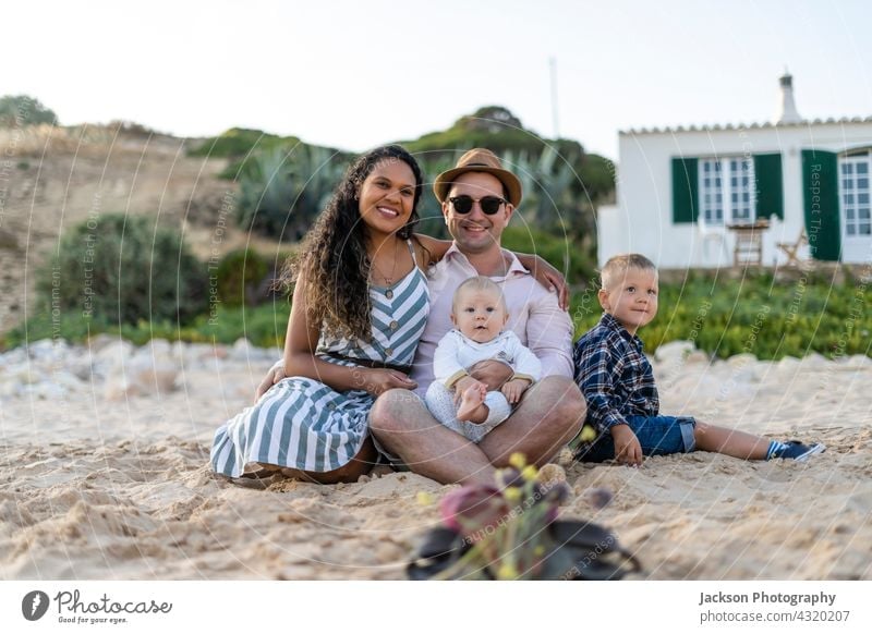 Die Familie mit zwei kleinen Jungen sitzt und posiert am Strand Porträt sitzen Zusammensein Sohn Kleinkind Baby Portugal Algarve Huckepack Erholung Kaukasier