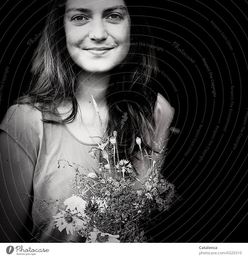 Lächelnde, junge Frau hält einen Wiesenblumenstrauß Natur Flora Person weiblich Blumen Pflanze schauen Blüte duften verblühen Blumenstrauß Margariten Kornblumen