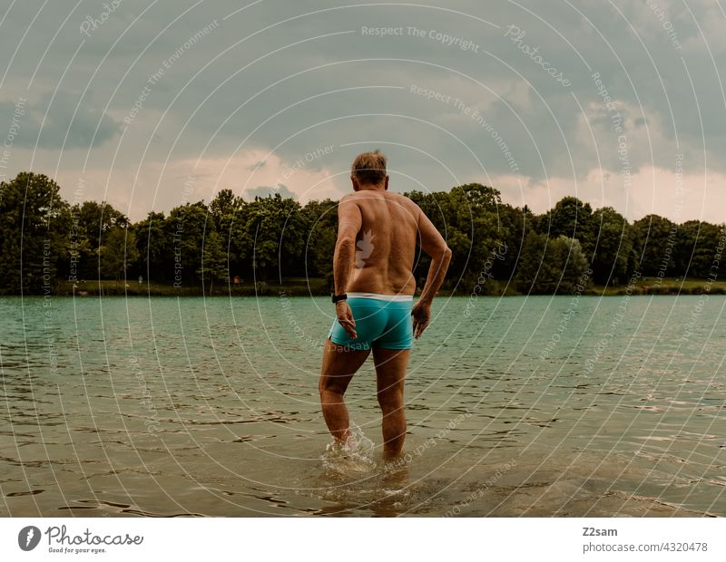 Sportlicher Rentner am See Schwimmende Wassersport Athlet Wiese rasen badesee sehen Freiwasser Schwimmsport Natur Wärme Sommer blauerhimmel wolken Training