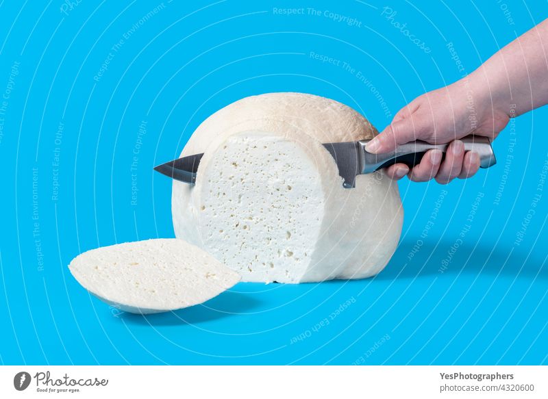 Frau schneidet von Hand Käse mit einem Messer. Block mit frischem Käse. Hintergrund groß Klotz blau Frühstück Chunk Nahaufnahme Farbe Kuh Küche geschnitten