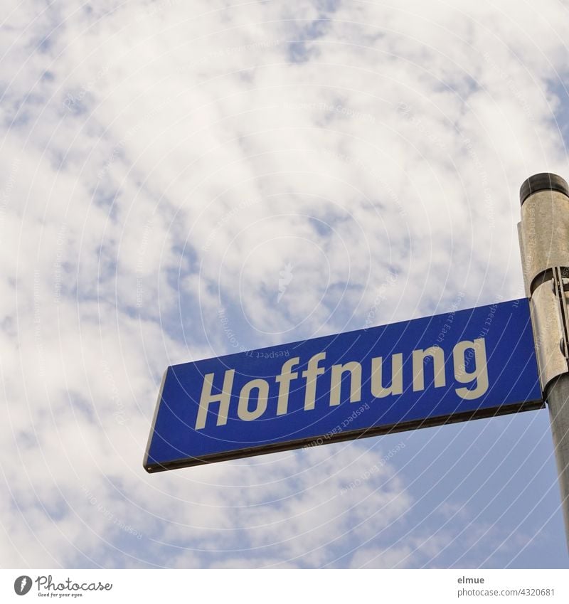 blaues Straßennamenschild " Hoffnung " an einer Eisenstange vor blauem Himmel mit Dekowolken / wohnen Schild Straßenschild Adresse Orientierung