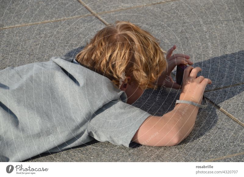 hinterrücks | Kind auf dem Boden beim Fotografieren fotografieren von hinten Rücken Aufnahme Junge Sommer Spaß Hobby Freizeit & Hobby Fotokamera Nachwuchs Azubi