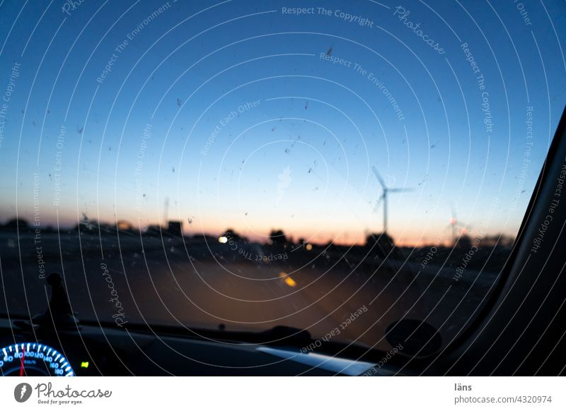 Autofahrt zur blauen Stunde blaue Stunde Dämmerung Abend Sonnenuntergang Licht Farbfoto Windrad Tacho Windschutzscheibe