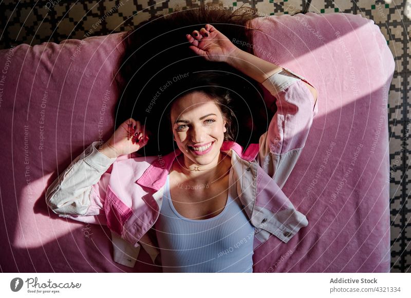 Unbeschwerte Frau liegt zu Hause auf dem Bett heimwärts Komfort sich[Akk] entspannen Sonnenlicht Schatten Schlafzimmer gemütlich weich Lügen ruhen Raum genießen