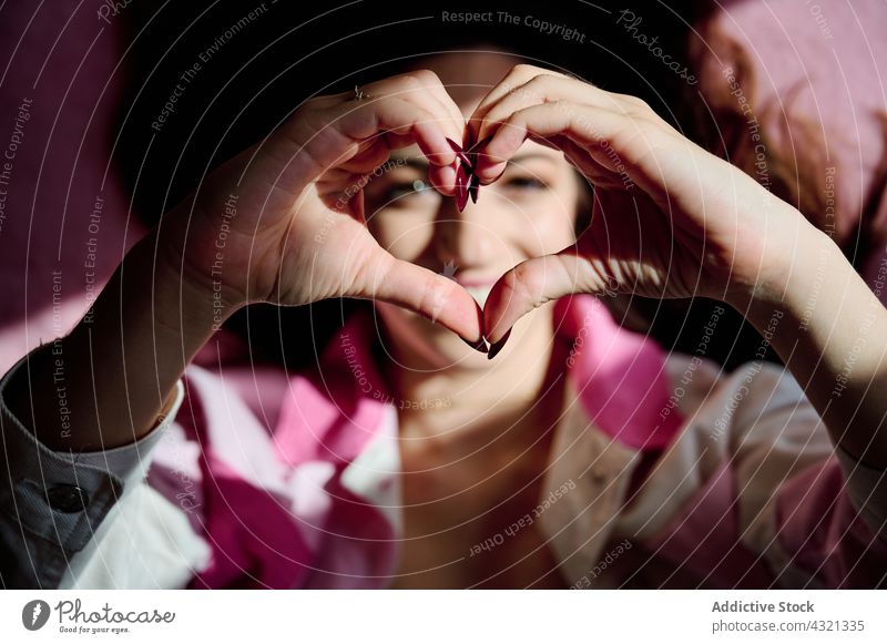 Frau zeigt Herzgesten in die Kamera Liebe gestikulieren Zeichen Valentinsgruß heiter romantisch Form Symbol Lächeln zeigen Glück positiv Stil Inhalt genießen