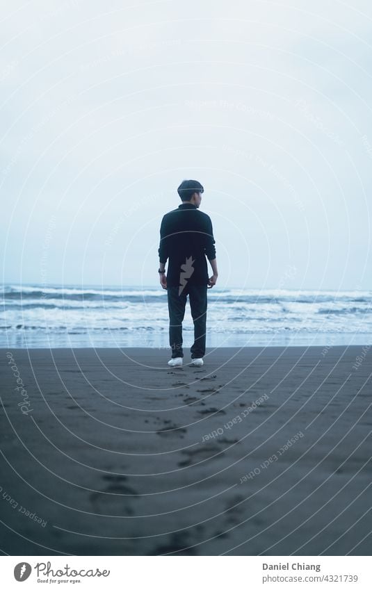 Männer mit seinem Fußabdruck am Strand Rücken Stimmung Außenaufnahme Meer Wasser Meeresstrand Wellen winken Stehen Blick jung Teenager allein einsam eine Person