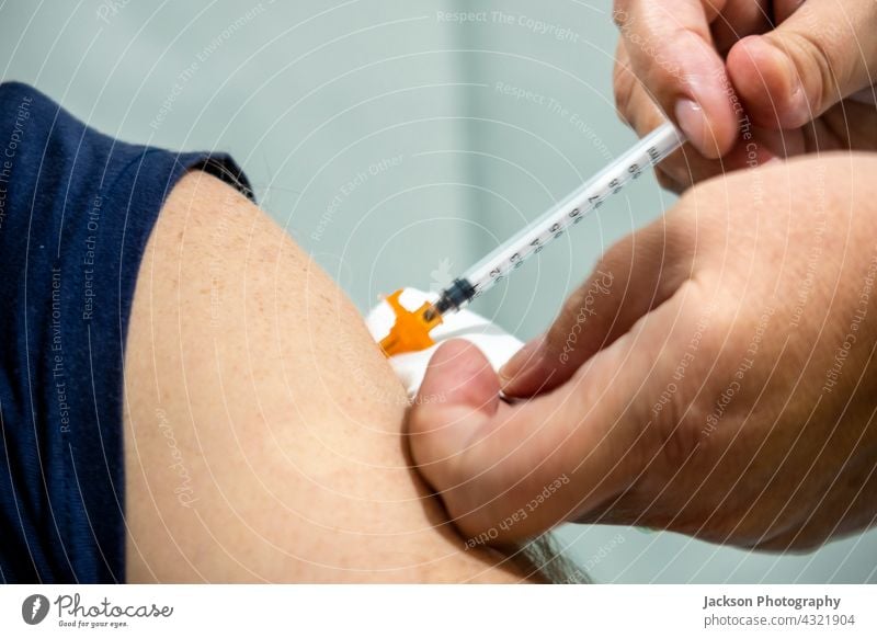 Ein Mann wird mit dem Impfstoff Covid 19 geimpft Spritze Impfung Bund 19 Nadel Medikament 2019-ncov Algarve Pflege Klinik Korona Corona-Virus Coronavirus COVID