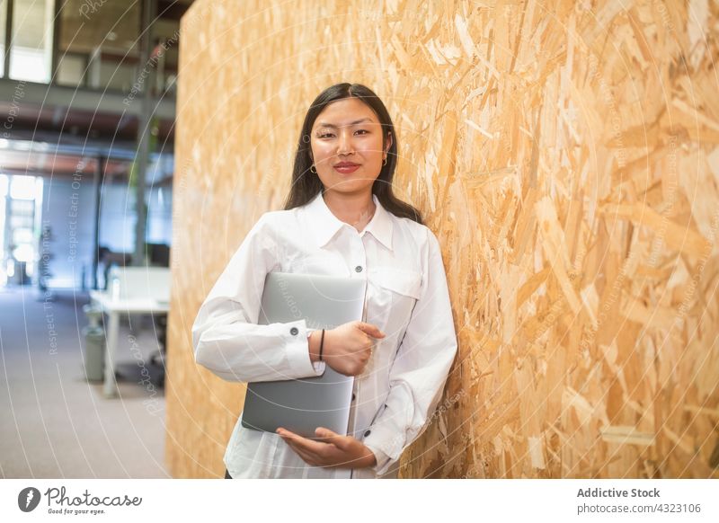 Asiatische Geschäftsfrau mit Laptop an einem modernen Arbeitsplatz Unternehmer asiatisch Cowork Raum Lächeln Computer Frau Büro respektabel gut gekleidet
