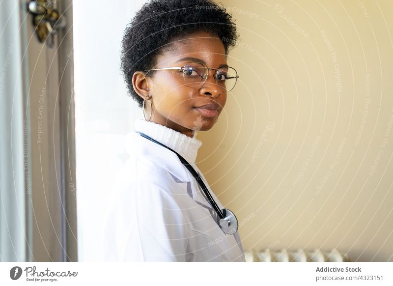 Selbstbewusste schwarze Ärztin mit Stethoskop schaut in die Kamera Arzt Sanitäter Frau Gesundheitswesen Klinik Praktiker selbstbewusst Porträt arzt jung