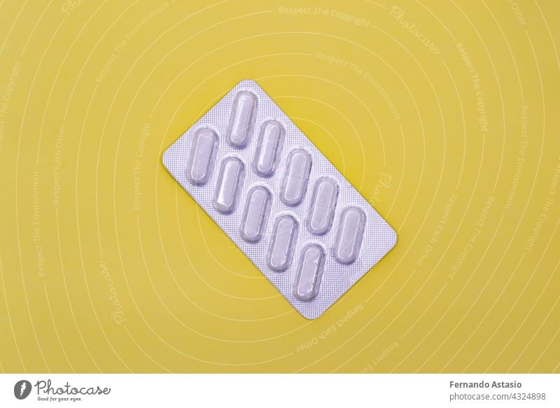 Packung mit weißen Pillen auf gelbem Hintergrund. Horizontale Fotografie. Medizin Tablette Gesundheit Postkarte medizinisch Apotheke Objekt Medikament Tabletten