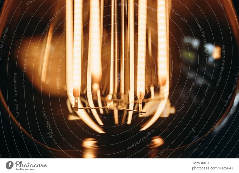 Nahaufnahme einer Glühbirne - die Drähte glühen erleuchten gelb Led Objektfotografie Bokeh-Effekt bokeh lichter Bokeh Hintergrund Hintergund Draht Design