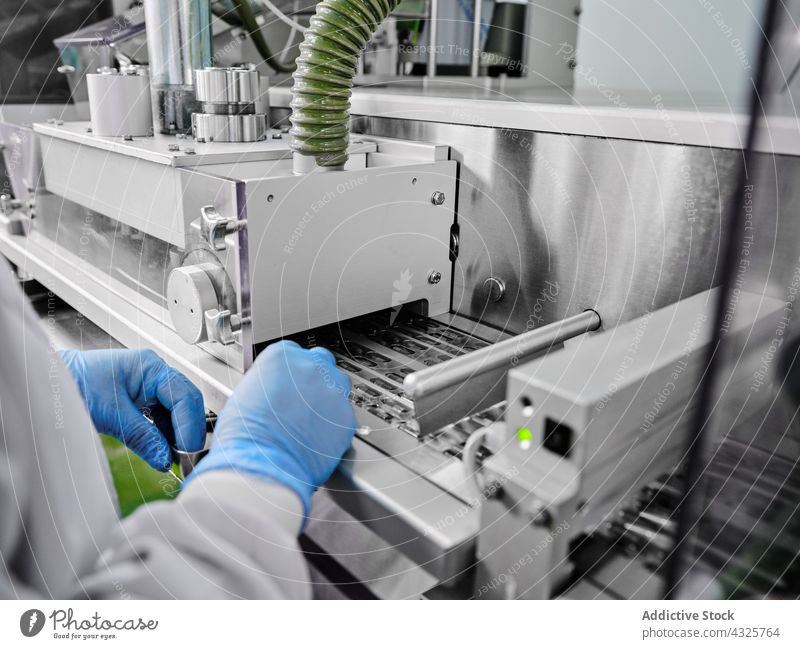 Arbeiter einer Pflanzenfabrik am Förderband mit Kapseln in Blistern Tablette Fabrik Herstellung Pharma Inszenierung Industrie industriell professionell