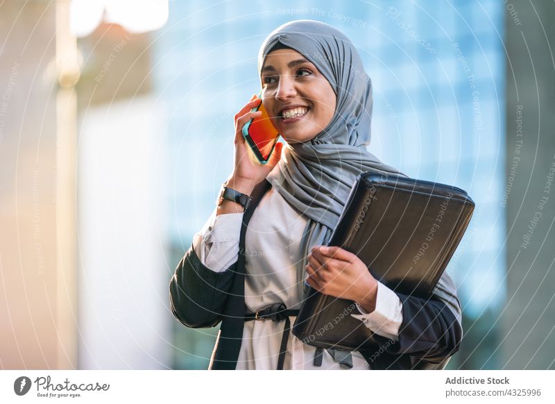 Muslimische Geschäftsfrau spricht in der Stadt mit ihrem Smartphone reden Unternehmer Hijab diskutieren Gespräch Mobile Telefon sprechen Frau ethnisch