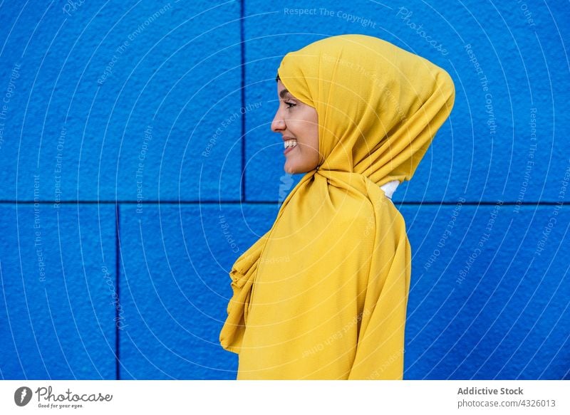 Stilvolle Muslima mit gelbem Kopftuch in der Stadt Frau Hijab Großstadt trendy Lächeln charmant Vorschein Tradition ethnisch muslimisch Straße Kultur Religion