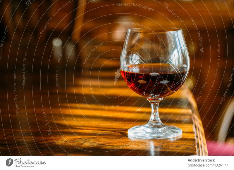 Cognacglas auf Holztisch mit natürlichem Licht Alkohol Hintergrund Barmann Barkeeper Getränk Bokeh Bourbon Cocktail trinken Lebensmittel Glas Lichter Schnaps