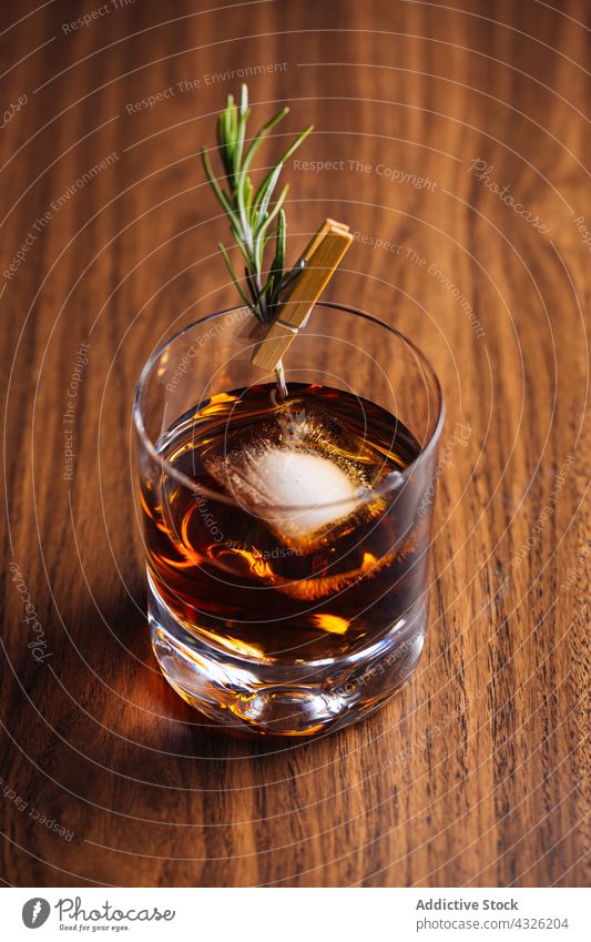 Ein Glas Whiskey mit Rosmarin Alkohol Hintergrund Barmann Barkeeper Getränk Bokeh Bourbon Cocktail Cognac trinken Lebensmittel Garnierung Eis Lichter Schnaps