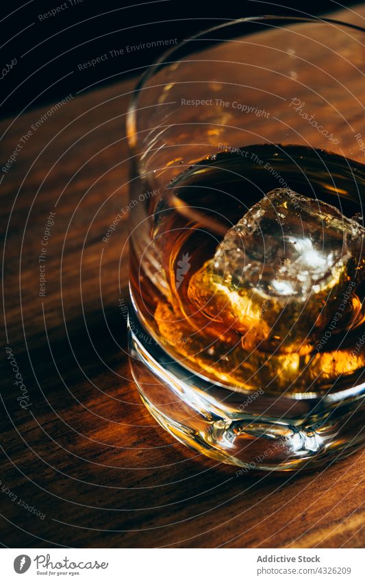 Glas mit Whiskey und Eis Tisch Tasse kalt trinken Alkohol dunkel Würfel Kristalle Container Getränk liquide cool Schnaps Holz Nutzholz hölzern Party Reichtum
