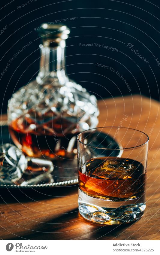 Glas Whiskey neben Karaffe Tisch Karaffen Tasse kalt Eis trinken Alkohol dunkel Kristalle Flasche Container Getränk liquide cool Zusammensetzung Schnaps Holz