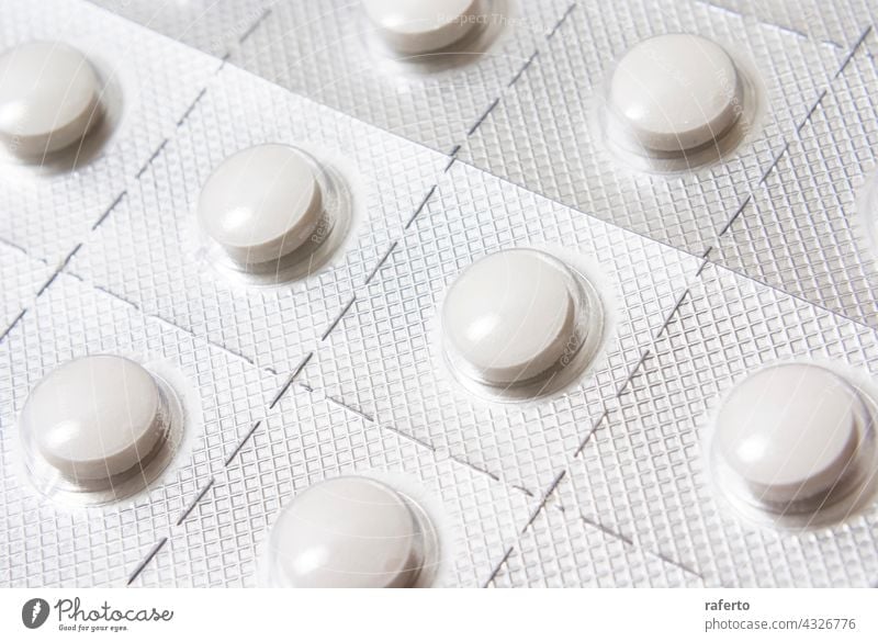 Weiße runde Tabletten in einem versilberten Blister Medizin Medikament Apotheke Antibiotikum Kapsel medizinisch Gesundheit Rudel Pharma Vitamin Pflege weiß