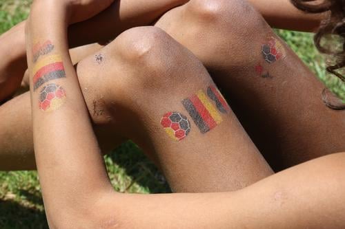 Kinder-Tattoos mit deutschem Fußball-Motiv auf Armen und Beinen eines Mädchen tätowiert Nationalität WM EM Deutschland Deutschlandfahne