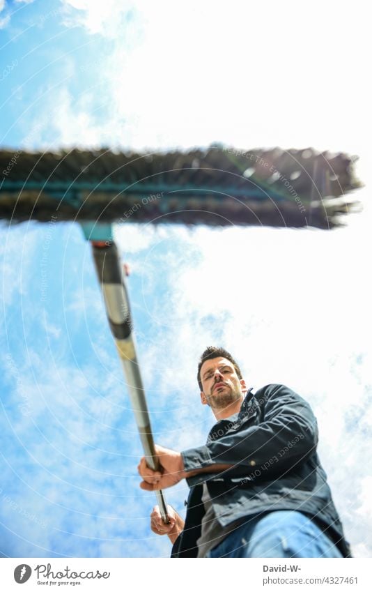 Mann fegt mit einem Besen säubern fegen Gartenarbeit Saubermann Ordnung fleißig Vorsätze Besenstiel Sauberkeit Häusliches Leben