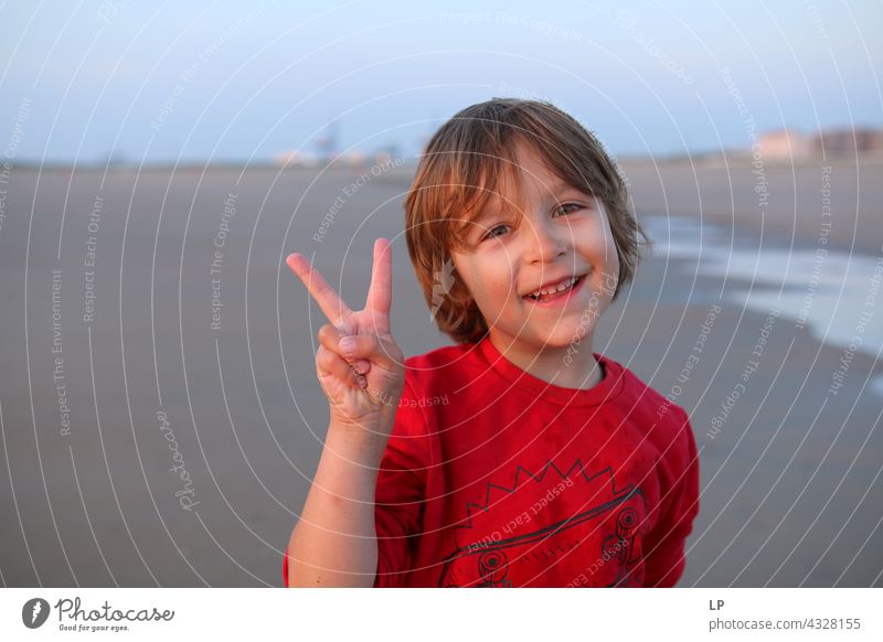 Junge lächelt und zeigt das V-Zeichen genießen Optimismus Religion & Glaube Anschluss positiv unschuldig spielerisch zeigend Hintergrundbild Fröhlichkeit