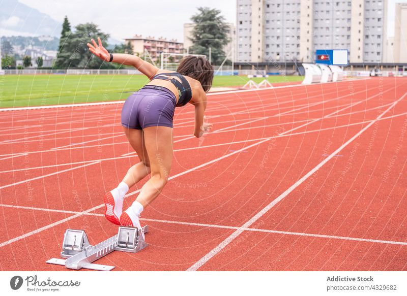 Sportliche Frau beim Sprint im Stadion Sportlerin Athlet Sprinter Start Bahn Läufer Bestimmen Sie Rennen schnell Geschwindigkeit Bewegung laufen Klotz Aktion