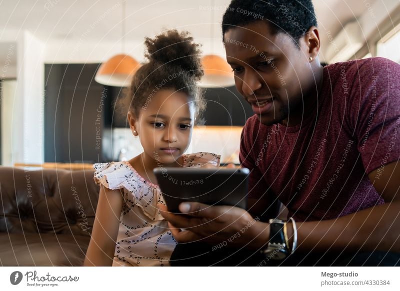 Vater und Tochter verwenden digitales Tablet zu Hause. monoparentiell spielen digitales Tablett Lifestyle Familie alleinerziehend im Innenbereich Aktivität