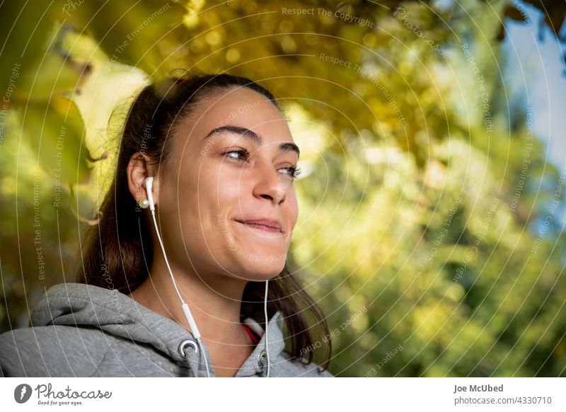 Junge Frau hört Musik während einer Trainingseinheit. Wellness-Lifestyle-Konzept Erwachsener Schönheit Schwarzes Haar Bekleidung Mantel Tageslicht Elektronik