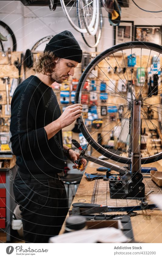 Mechaniker repariert Fahrradrad in der Werkstatt Reparatur Rad fixieren Mann Reifen Dienst Arbeit Flugzeugwartung professionell männlich Techniker Fähigkeit