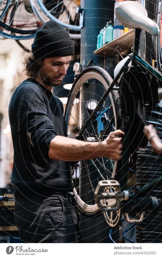 Mechaniker repariert Fahrradrad in der Werkstatt Reparatur Rad fixieren Mann Reifen Dienst Arbeit Flugzeugwartung professionell männlich Techniker Fähigkeit