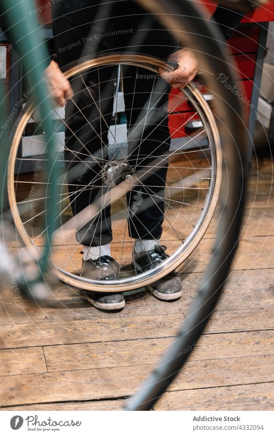 Anonymer Mann repariert Fahrrad in Garage - ein lizenzfreies Stock