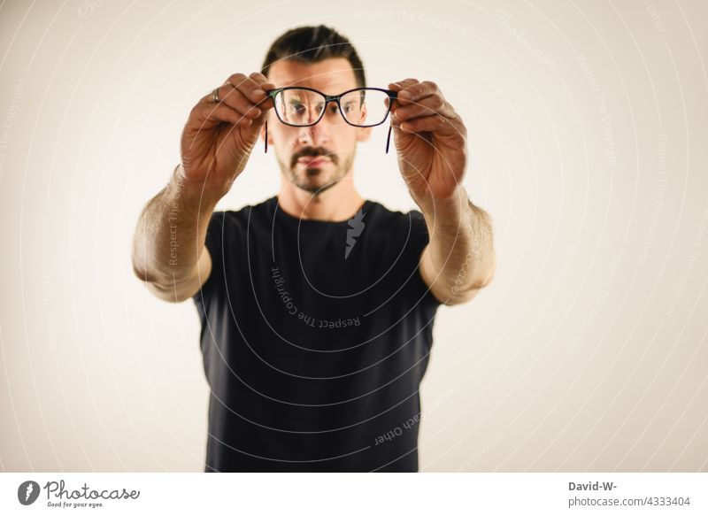 genau hinschauen - Mann schaut durch eine Brille Durchblick beobachten suchen Augen Sehvermögen Brillenträger Optik Brillenglasstärke blind