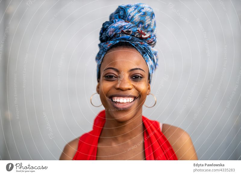 Junge Frau mit bunter Kopfbedeckung Afro-Look stolz echte Menschen Stadtleben Afroamerikaner Afrikanisch Schüler schwarz Ethnizität sonnig Sonnenuntergang