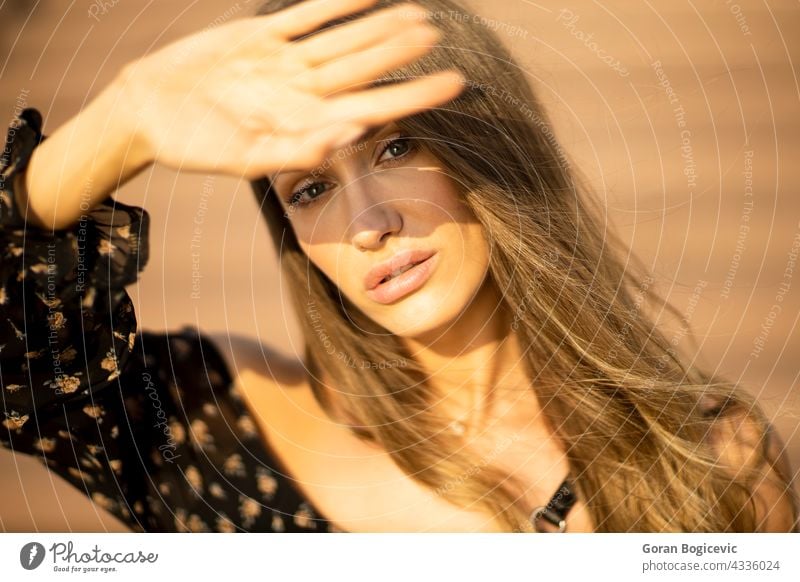 Outdoor-Porträt von sinnlichen langen Haaren brunette weibliche Abdeckung ihr Gesicht mit der Hand aus Sonnenlicht Erwachsener attraktiv schön Schönheit brünett